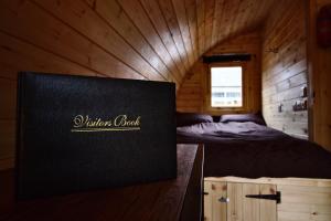 a room with a bed in a wooden cabin at Coe Pod, West Highland Way Holidays in Kinlochleven