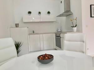 a kitchen with a bowl of fruit on a white table at Ocean Apartment in Zagreb