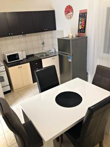 a kitchen with a white table with chairs and a refrigerator at Old SALONA in Solin