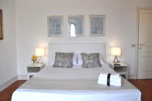 una camera da letto con un grande letto bianco con due lampade di Villa Luce B&B a Olbia