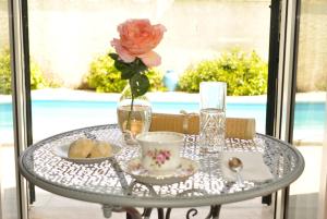 a glass table with a vase with a flower on it at Villa Luce B&B in Olbia