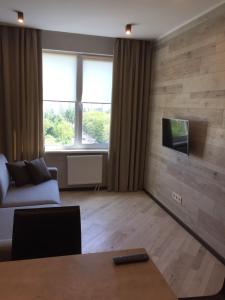 uma sala de estar com um sofá e uma televisão na parede em Apartament West Side em Kiev