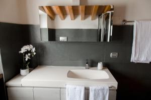 łazienka z białą umywalką i lustrem w obiekcie Casa Amalia w mieście Bardolino +24 zdjęcia