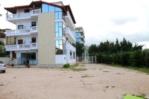 un gran edificio blanco con muchas ventanas en Villa Ideal, en Ksamil