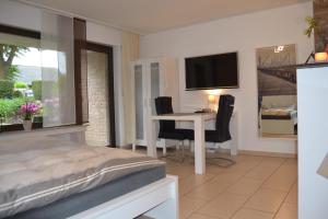Schlafzimmer mit einem Bett, einem Schreibtisch und einem TV in der Unterkunft Ferienwohnung Schelsen in Mönchengladbach
