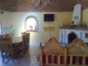 uma sala de estar com uma mesa e uma lareira em VILLA COLONIAL em Tequisquiapan