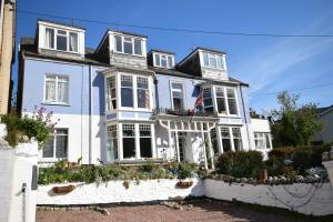 a white house with a flag on it at Newberry Beach lodge in Combe Martin