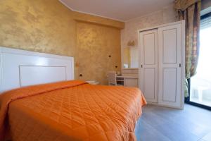 a bedroom with an orange bed and a door at Hotel Diplomat Palace in Rimini