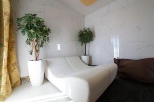 a white couch in a room with two potted plants at Hotel Diplomat Palace in Rimini