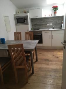 cocina con mesa de madera y sillas en Privatzimmer Wagner en Leoben