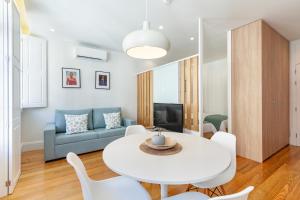 uma sala de estar com uma mesa branca e cadeiras em Polery Apartments Center em Guimarães