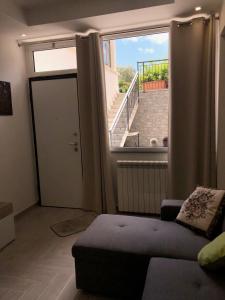 ein Wohnzimmer mit einem Sofa und einem großen Fenster in der Unterkunft Casa Tatiana in Palermo