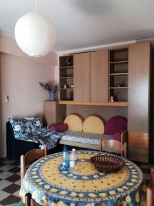a living room with a table and a bed at Appartamento nel verde in Fronte Aguglieri