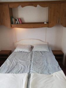 1 cama con 2 almohadas en una habitación en Domek holenderski Adaś, en Gawliki Wielkie