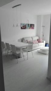 sala de estar con mesa, sillas y sofá en Edificio Attikos, en Playa de Gandía