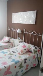 1 dormitorio con 2 camas y colcha con flores en Edificio Attikos, en Gandía