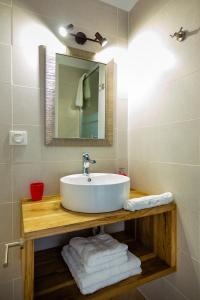 a bathroom with a sink and a mirror and towels at Appart Hotel Martinique - Mellow Yellow in Ducos