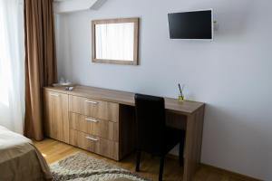 una camera da letto con scrivania, sedia e specchio di Casa Muntenească Alessandro a Piteşti