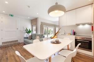 a kitchen and living room with a white table and chairs at Polery Apartments Center in Guimarães