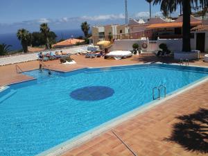 una gran piscina azul con gente sentada a su alrededor en The BlueStudio, en Tacoronte