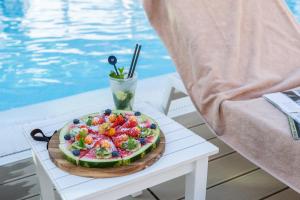 a plate of fruit on a table next to a pool at Almar Jesolo Resort & Spa in Lido di Jesolo