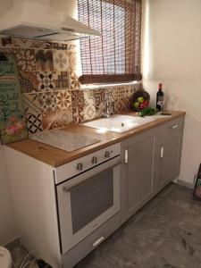 a kitchen with a stove and a sink and a window at Aelia Houses in Agia Marina Aegina +76 photos
