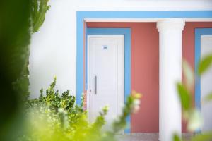 a house with a blue and white door at Akti Dimis Hotel in Tigaki