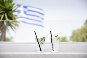 two cocktails sitting on a table in front of a window at Akti Dimis Hotel in Tigaki