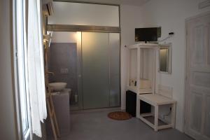 een badkamer met een toilet en een glazen schuifdeur bij Andriani's Guest House in Mykonos-stad