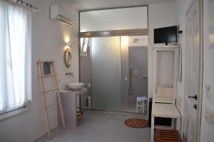 een badkamer met een douche, een wastafel en een toilet bij Andriani's Guest House in Mykonos-stad