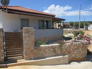 a house with a fence and a stone wall at Vila Horizont Ksamil in Sarandë