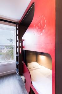 czerwone łóżko piętrowe w pokoju z oknem w obiekcie Bazpackers w mieście Inverness