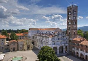 ein großes Gebäude mit einem Turm und einem Uhrturm in der Unterkunft Angelini dal 1911 in Lucca