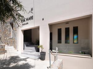 a white building with stairs in front of it at Eva Mare Hotel & Suites - Adults only in Agia Pelagia