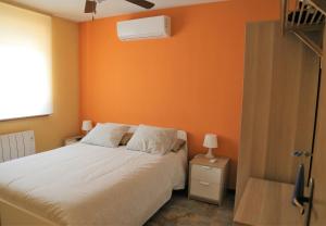 ラ・アドラダにあるLa Vegaのベッドルーム1室(オレンジ色の壁のベッド1台付)