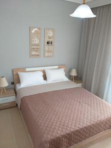 a bedroom with a large bed and two lamps at Castle View Apartment in Kavala