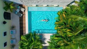 a person swimming in a swimming pool next to a building at The Diplomat Boutique Hotel in Mérida
