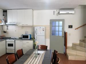 a kitchen with a table with chairs and a refrigerator at Complejo Kalifornia in Pilar