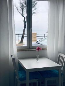 een tafel en twee stoelen voor een raam bij Terra del SUD in Giovinazzo