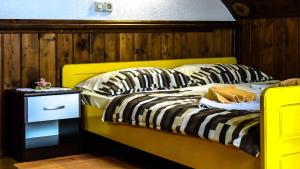 a yellow bed with striped pillows in a room at Apartment Franciska in Rakovica