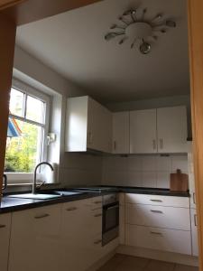 a kitchen with white cabinets and a ceiling fan at Meeresbrise in Graal-Müritz