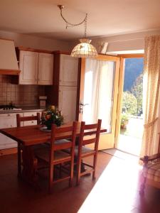 a kitchen with a table and chairs and a window at Albergo Garnì Maso Mistrin in Madonna di Campiglio