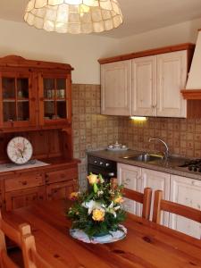 a kitchen with a table with a vase of flowers on it at Albergo Garnì Maso Mistrin in Madonna di Campiglio