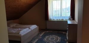 A bed or beds in a room at Penzion Montana