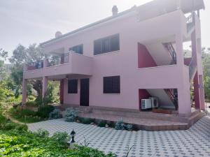 ein weißes Haus mit einem Balkon und einem Innenhof in der Unterkunft Guest house Maslina in Vinišće