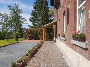 eine offene Tür zu einem Backsteingebäude mit einer Terrasse in der Unterkunft Haus am Sachsenring in Hohenstein-Ernstthal