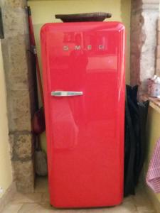um frigorífico vermelho está sentado num quarto em LA BICO' em Pitigliano