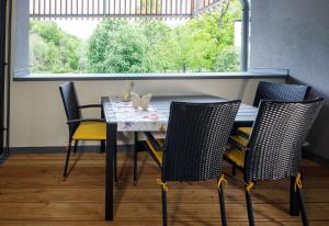 einem Esstisch mit 4 Stühlen und einem Fenster in der Unterkunft Ferienwohnung Narzisse - City Appartement im Kurpark Bad Aussee in Bad Aussee