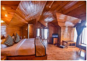 ein Schlafzimmer mit einem großen Bett in einem Zimmer mit Holzwänden in der Unterkunft Cedar Inn in Darjeeling