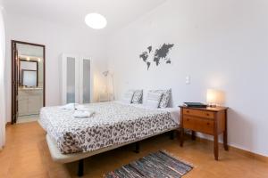 1 dormitorio con cama, tocador y mesa en 3 Marias Garden House B&B, en Lagos